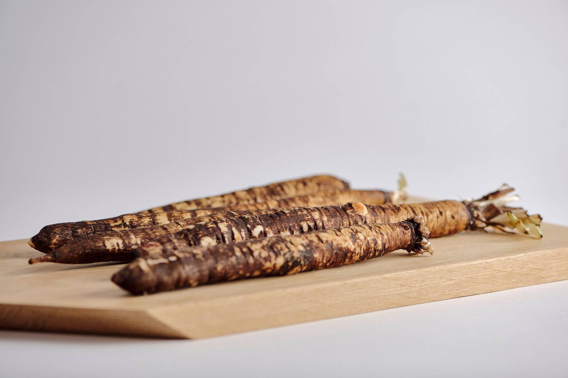 black-salsify black salsify on a wooden board with white background