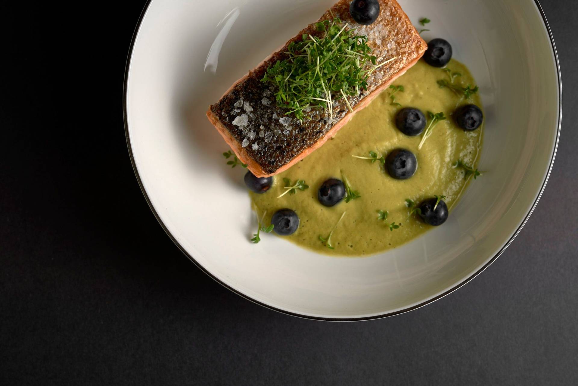 pan-fried-salmon-with-asparagus-matcha-sauce-and-blueberries pan fried salmon with asparagus matcha sauce and blueberries on a white plate with black background