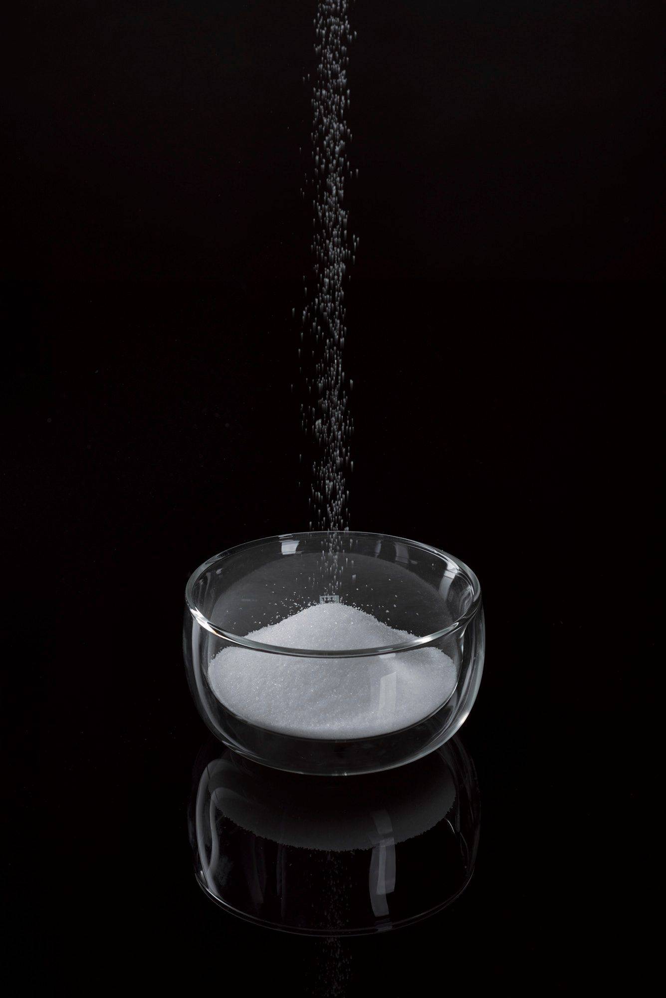 salt-and-sugar salt and sugar in a glass bowl with black background