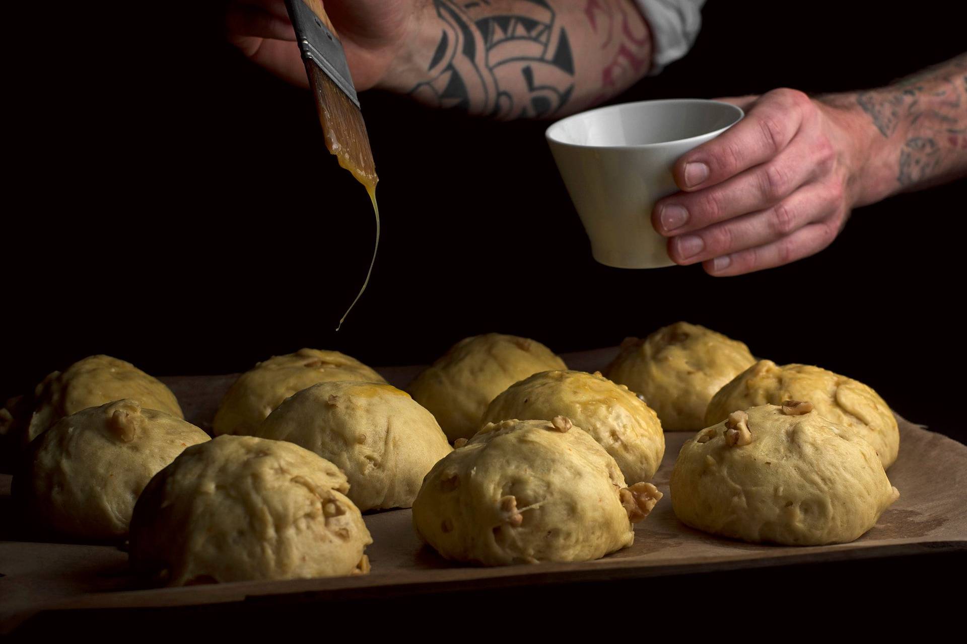 making-brioche-buns-with-walnuts egg brushing brioche buns with walnuts