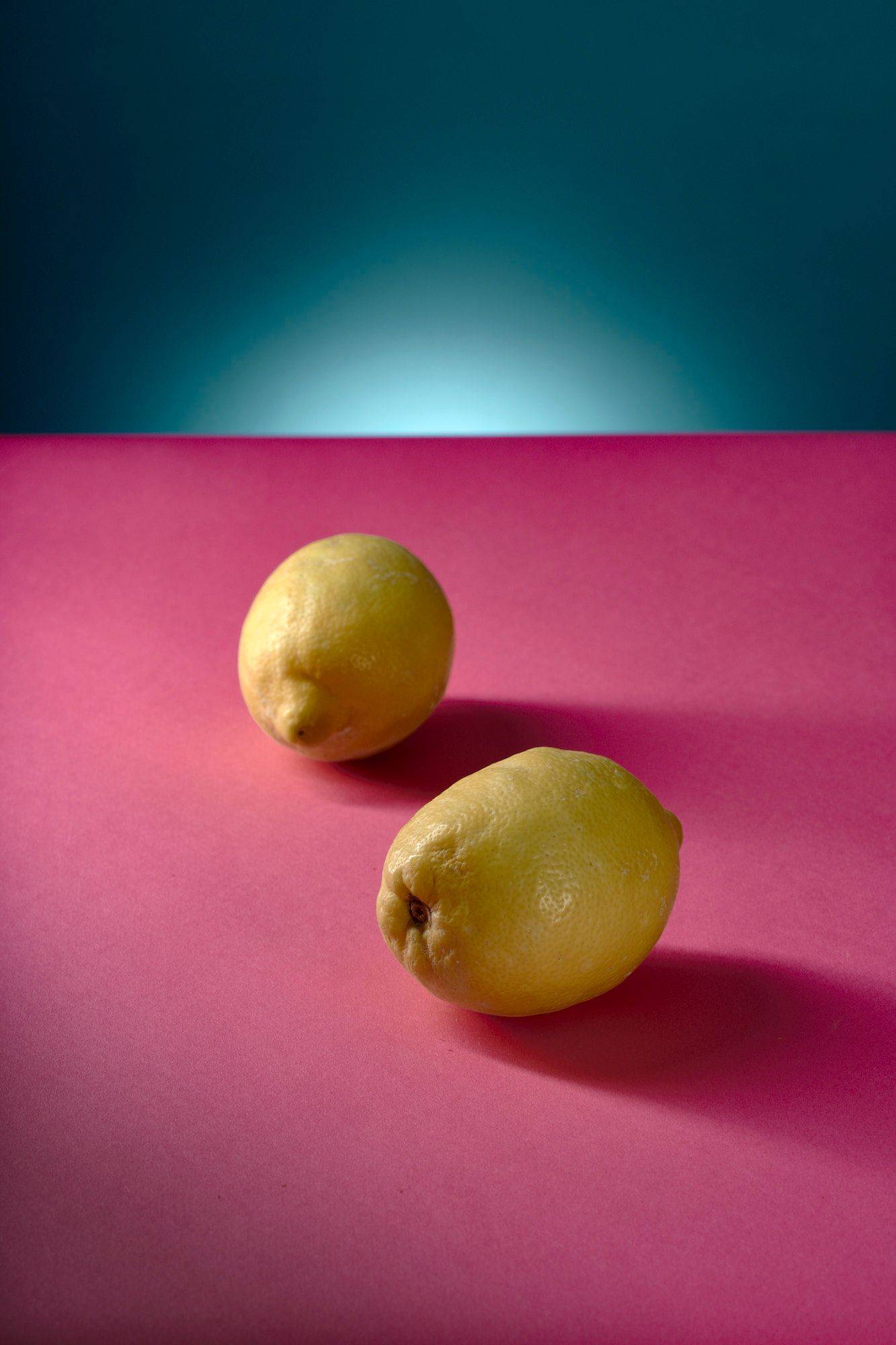 lemons two lemons with pink and blue background
