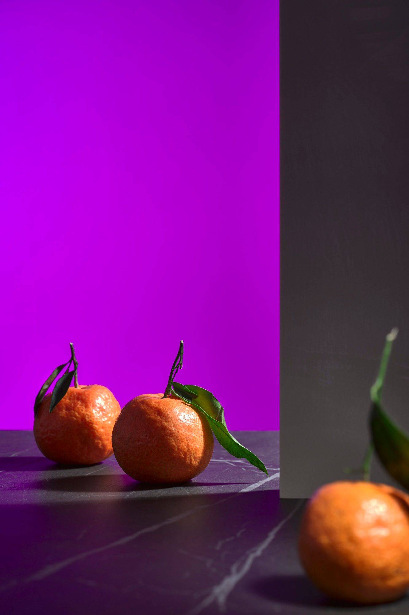 tangerines three tangerines with green on a gray marbled sapienstone top with purple background