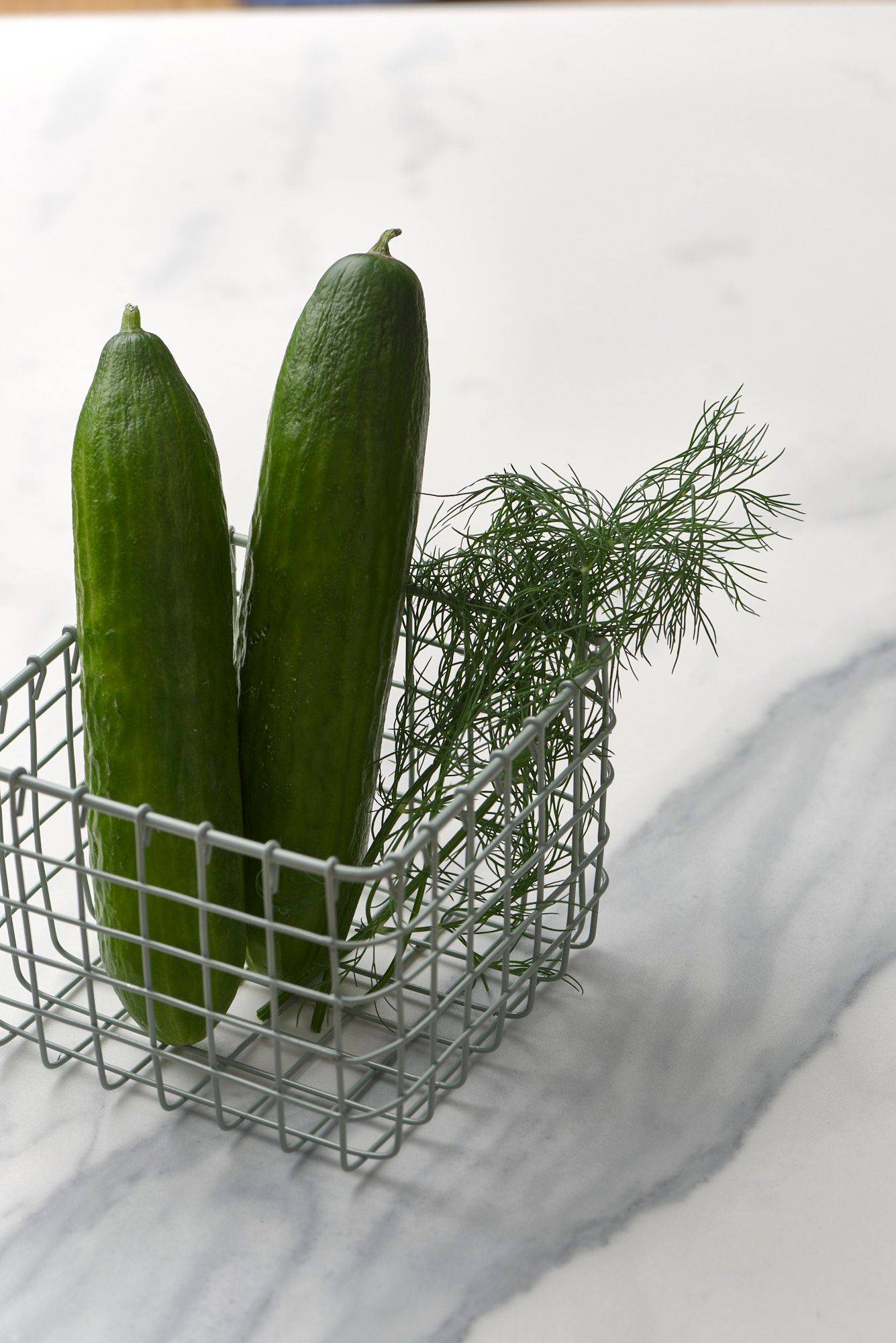 cucumbers-and-dill two cucumbers and dill in a small basket with a marbled sapienstone top