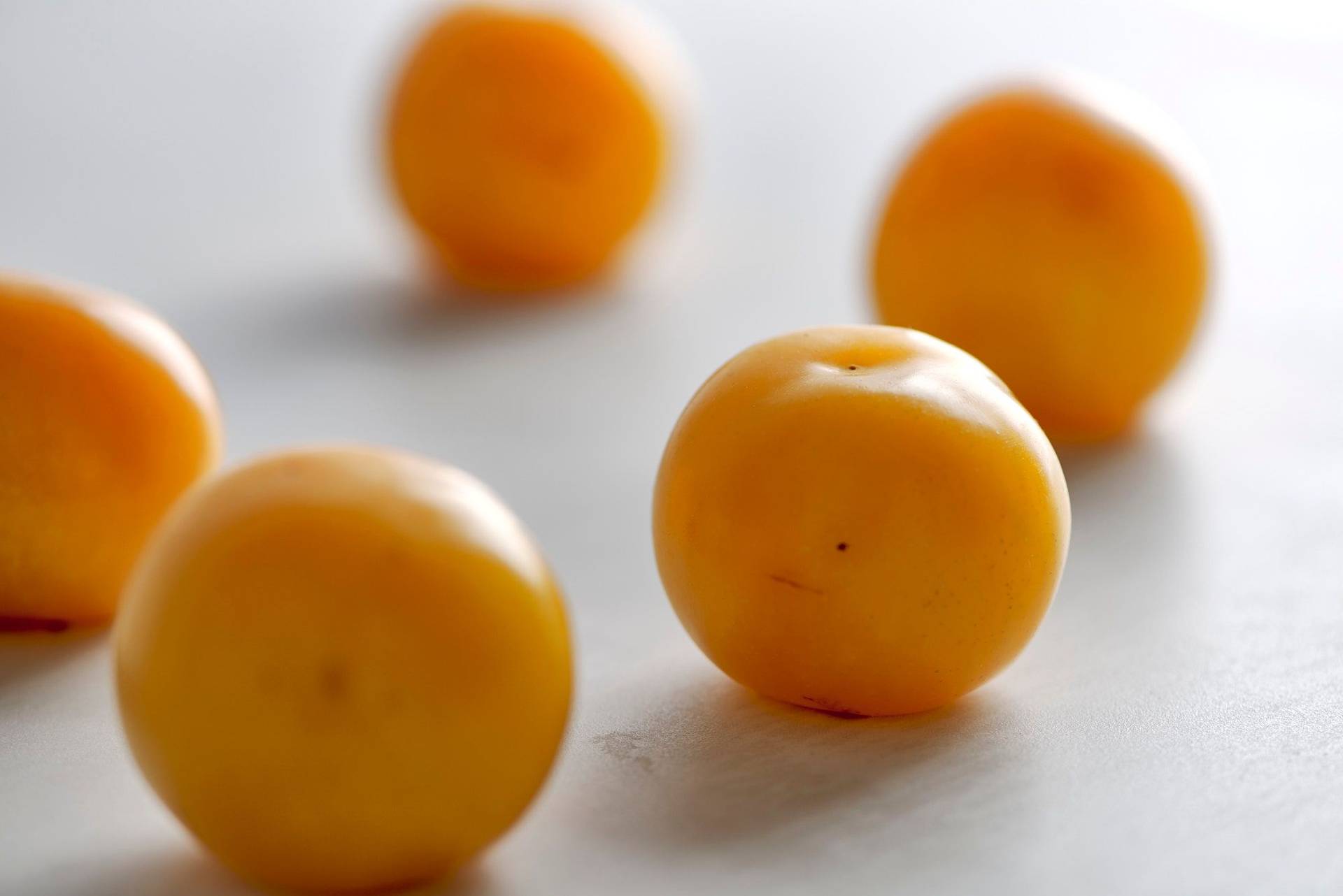 yellow-plums five yellow plums on a white sapienstone top