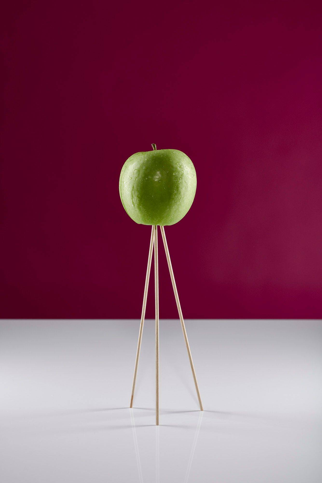 green-apple green apple on wooden skewers with white and pink background