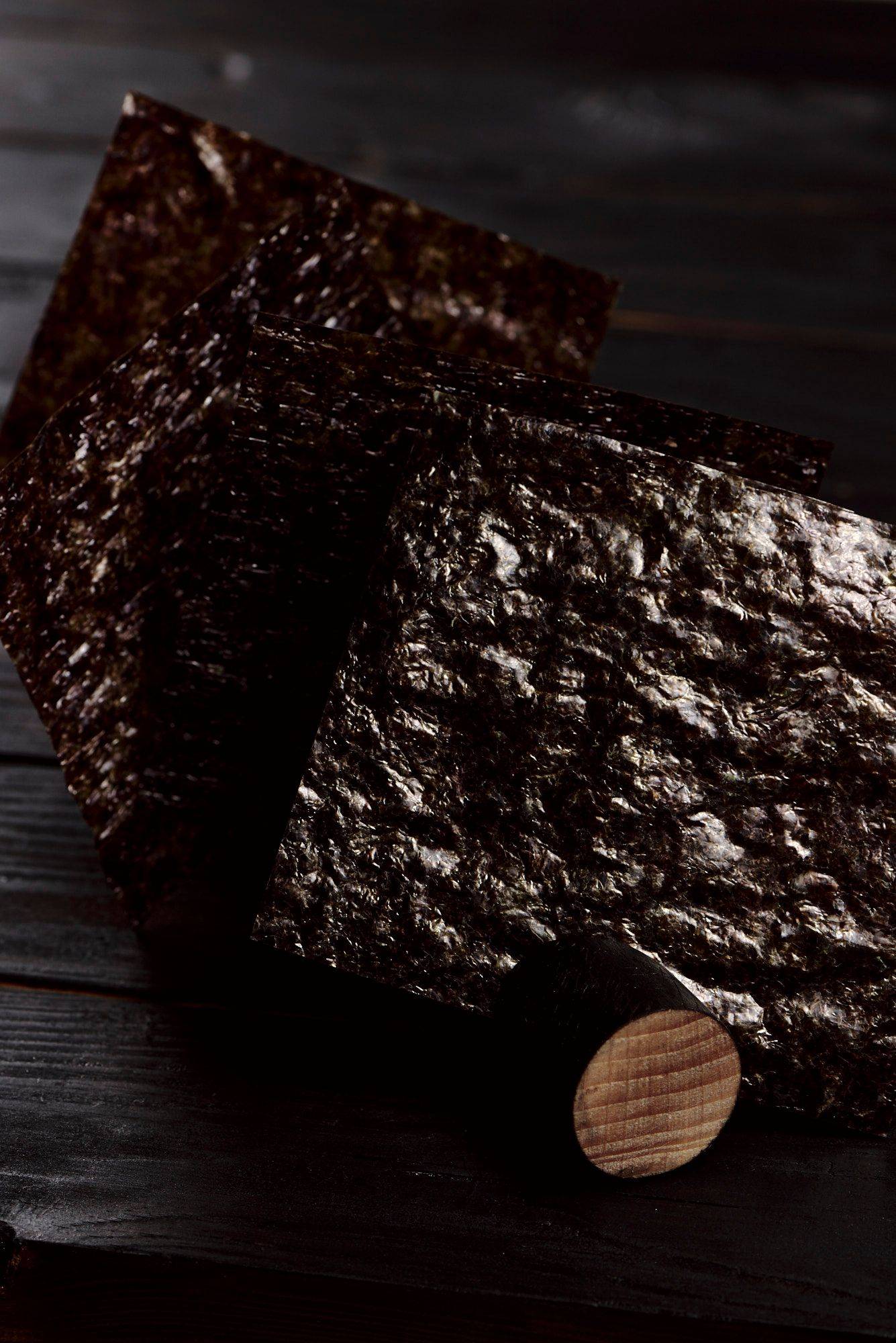 nori-leaves nori leaves with black wooden background