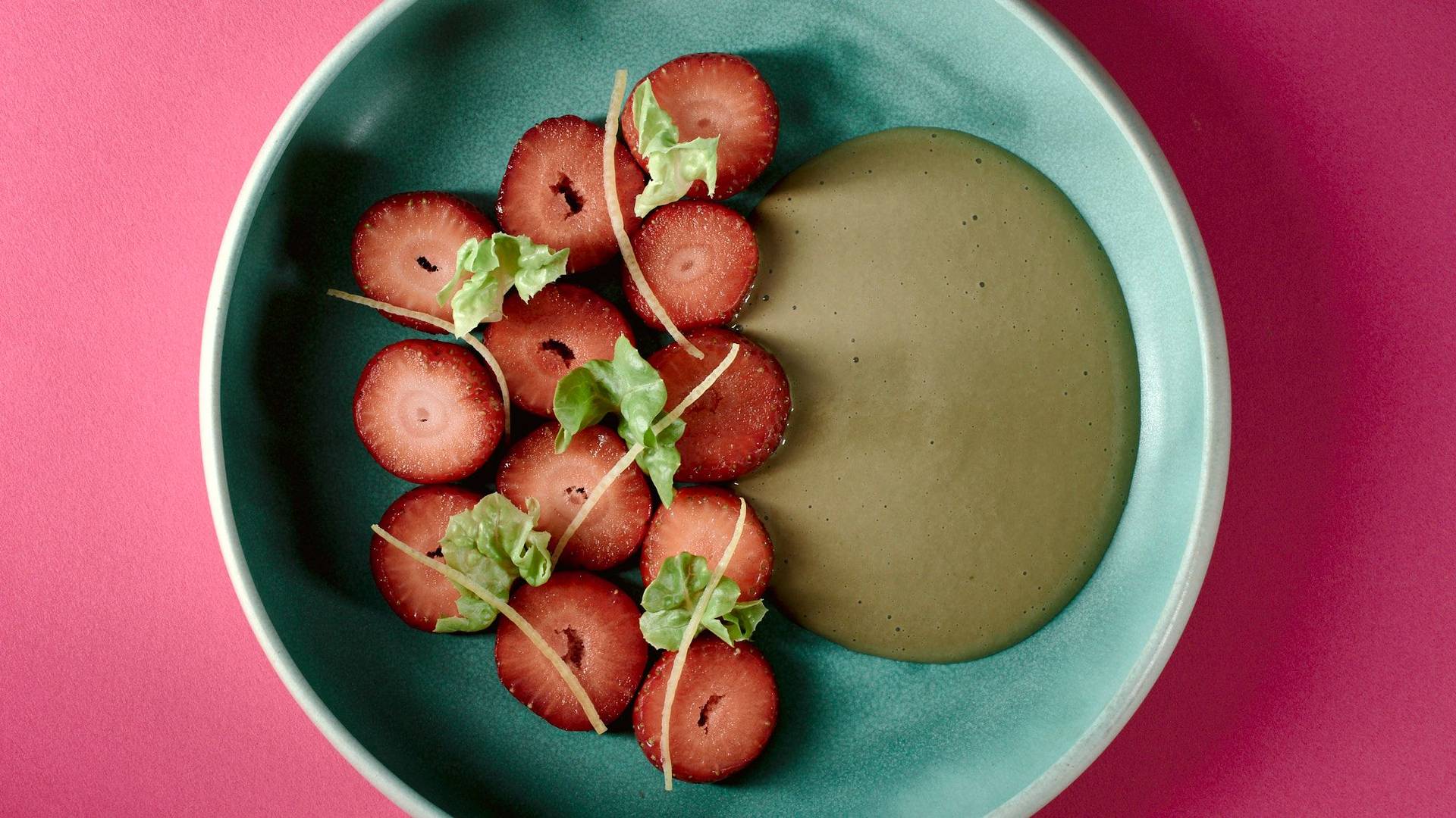 vegan-strawberry-dessert-with-lettuce-and-sunflower-seeds vegan strawberry dessert with lettuce and sunflower seeds on a turquoise plate with pink background