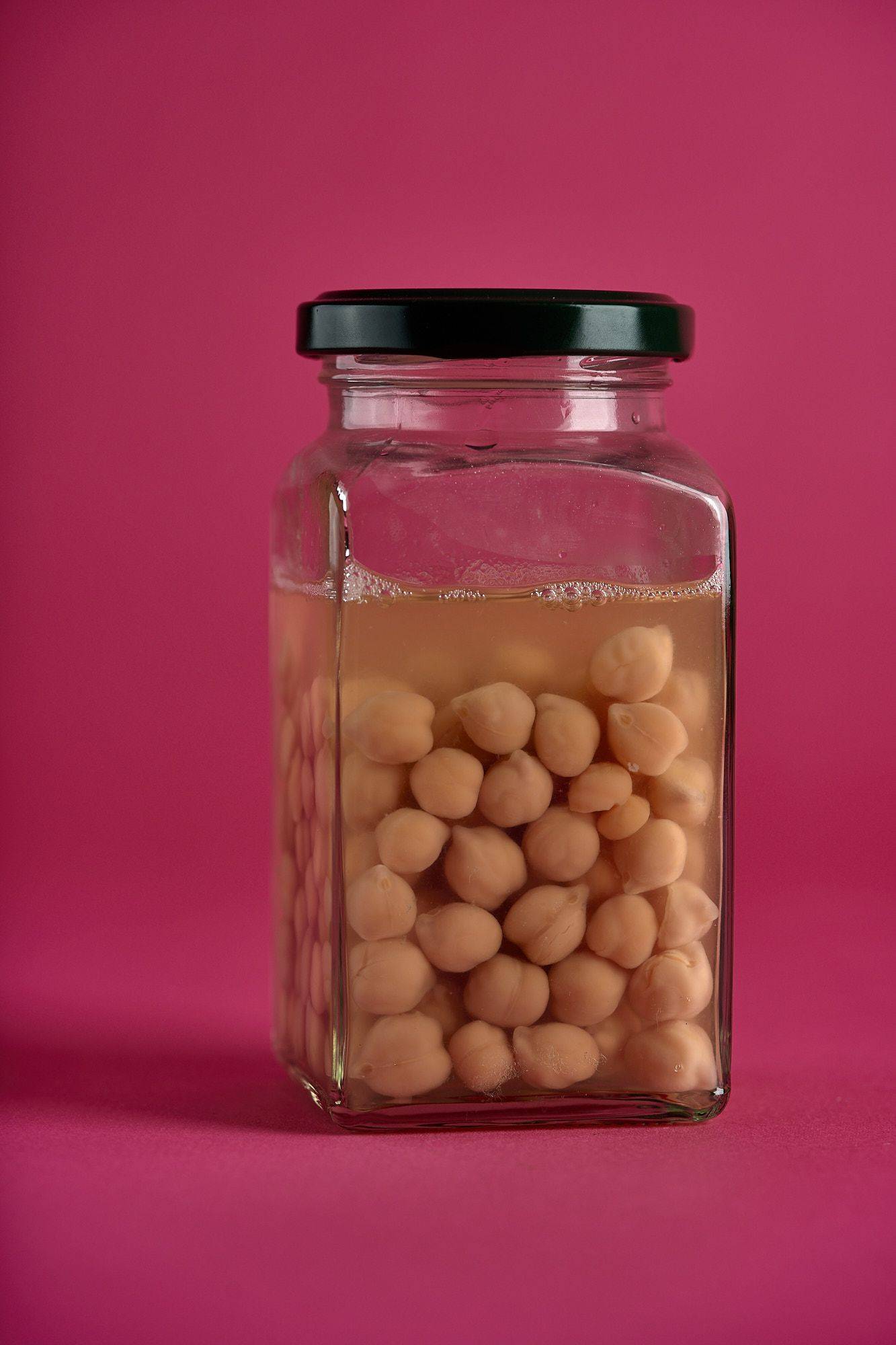 chickpeas a jar with chickpeas on pink background