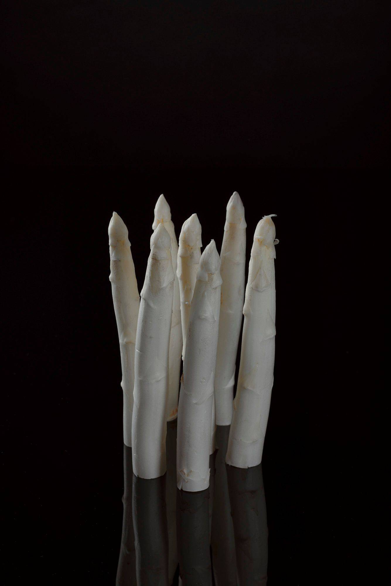 white-asparagus seven pieces of white asparagus with black background