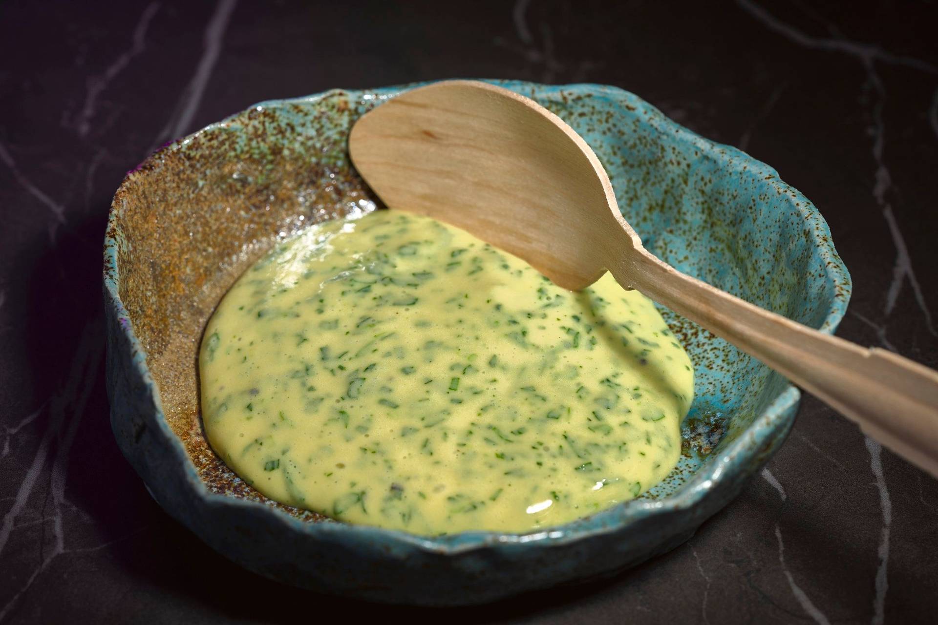 homemade-terragon-mayonnaise homemade terragon mayonnaise in a turquoise ceramic bowl with wooden spoon on a gray marbled sapienstone top