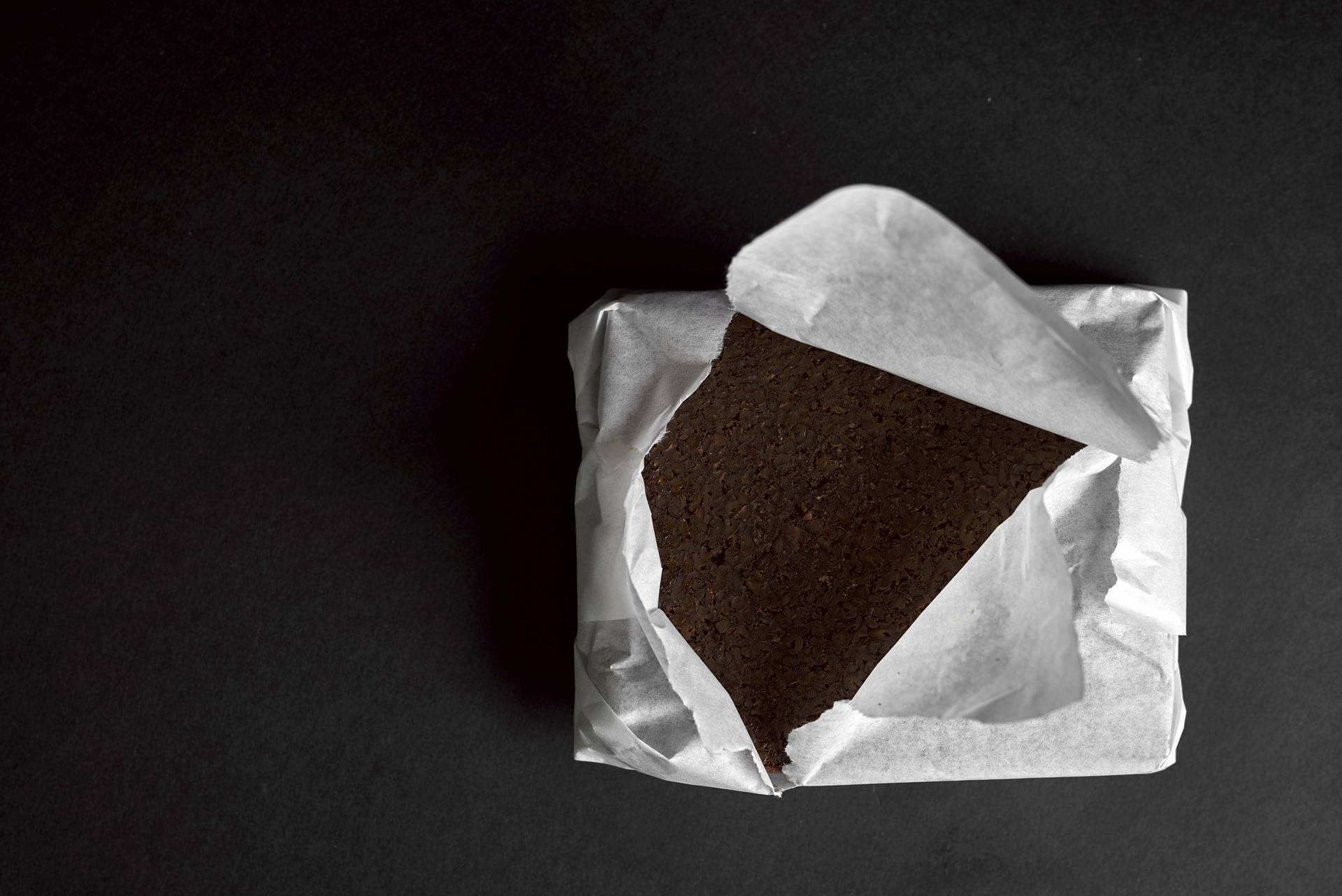 pumpernickel-bread pumpernickel bread wrapped in paper with black background