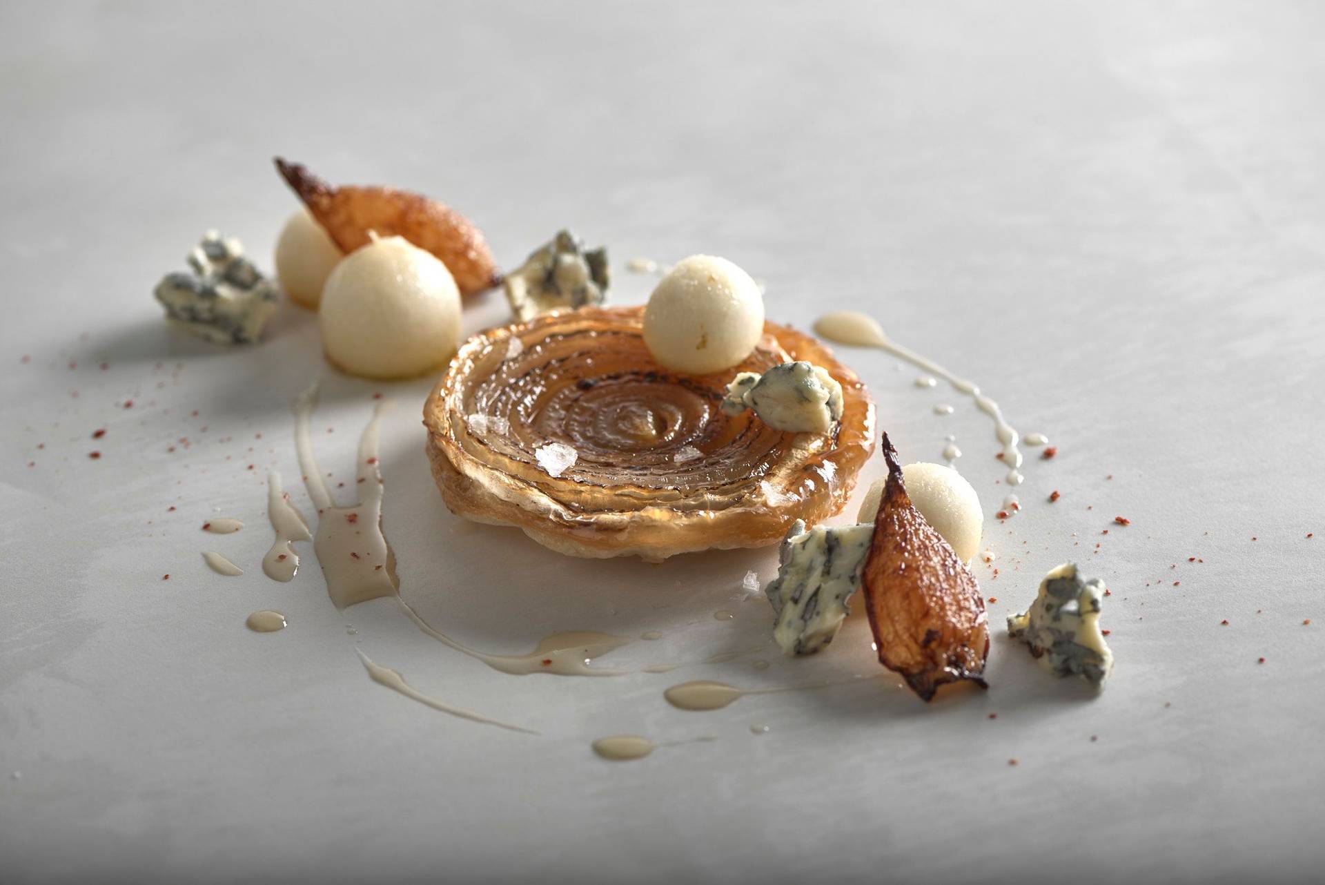 onion-tarte-tatin-with-blue-cheese-and-pear onion tarte tatin with blue cheese and pear on a white stone table