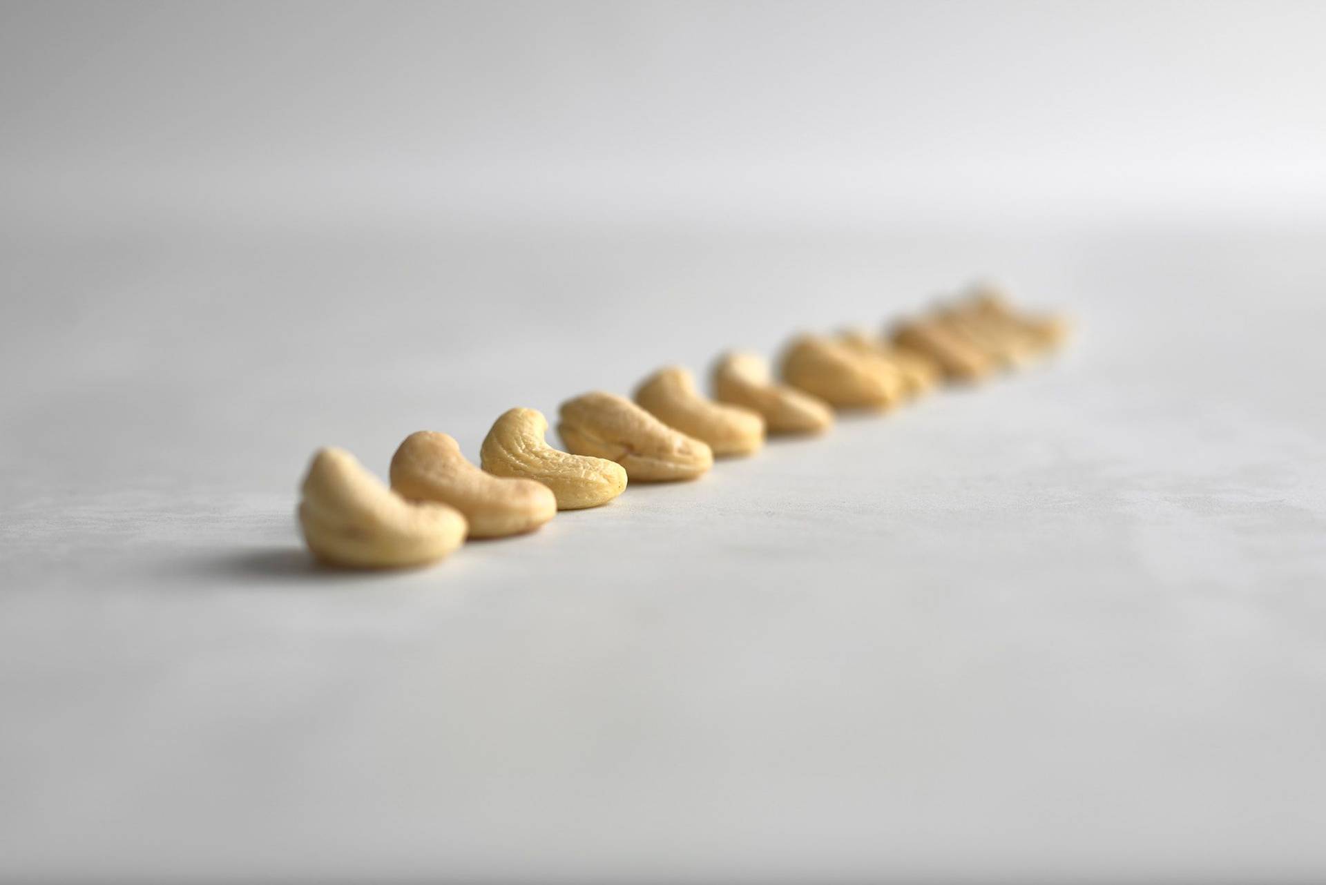 cashew-nuts cashew nuts in a row on a white sapienstone top