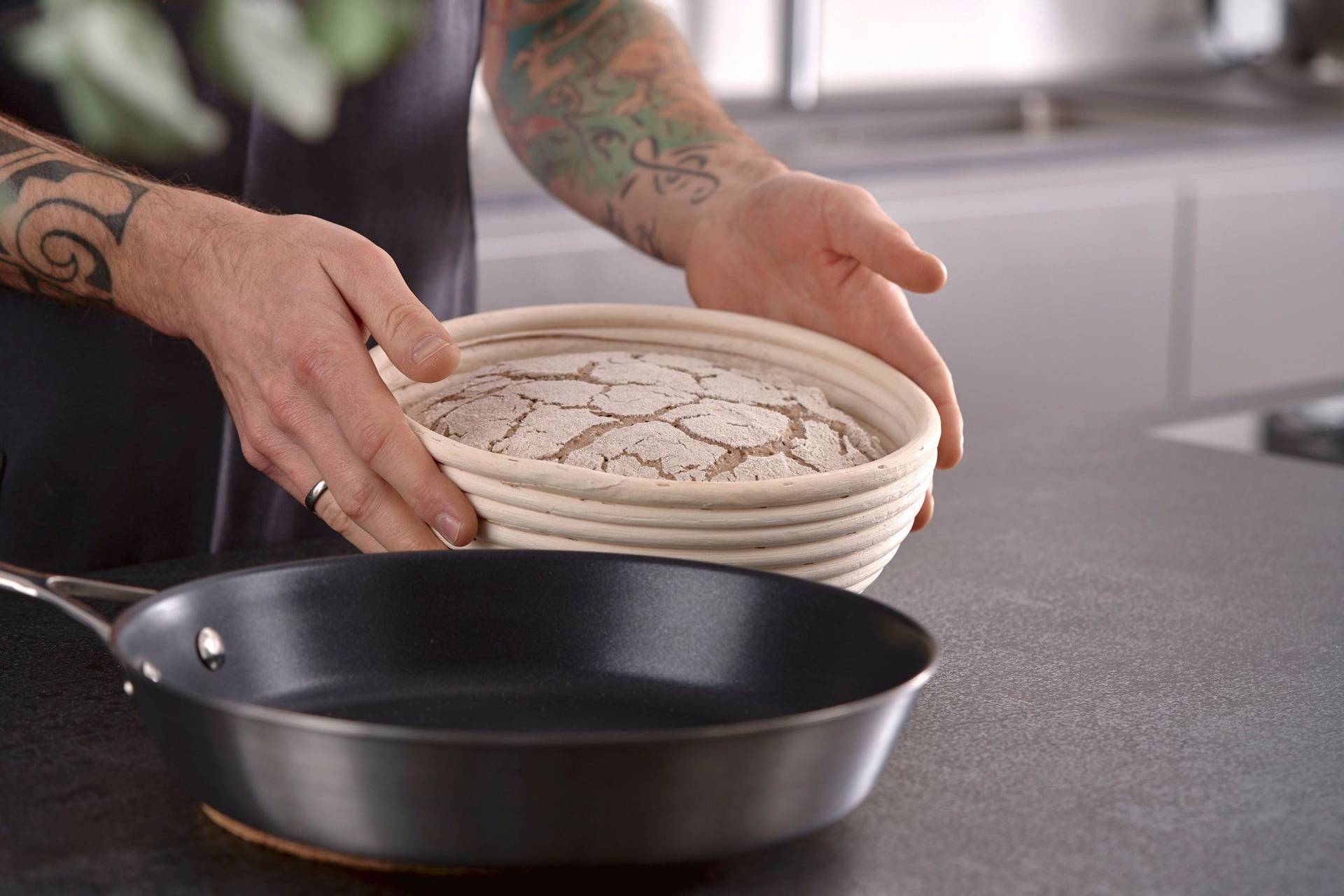 proofed-rye-sourdough-bread man holds proofed rye sourdough bread in home kitchen