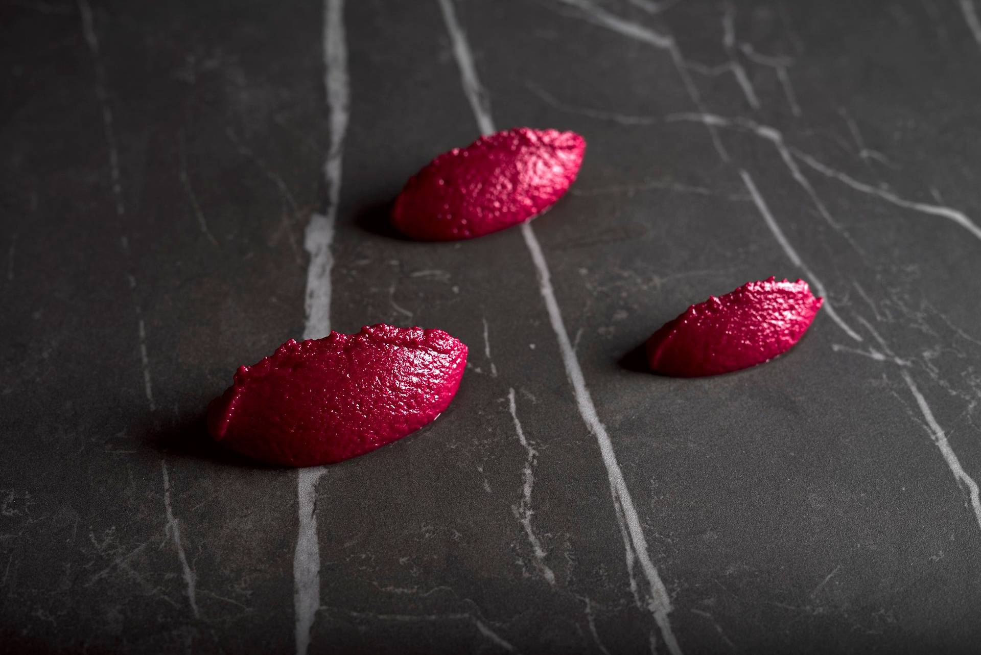 beetroot-hummus three spoons of beetroot hummus on a gray sapienstone top
