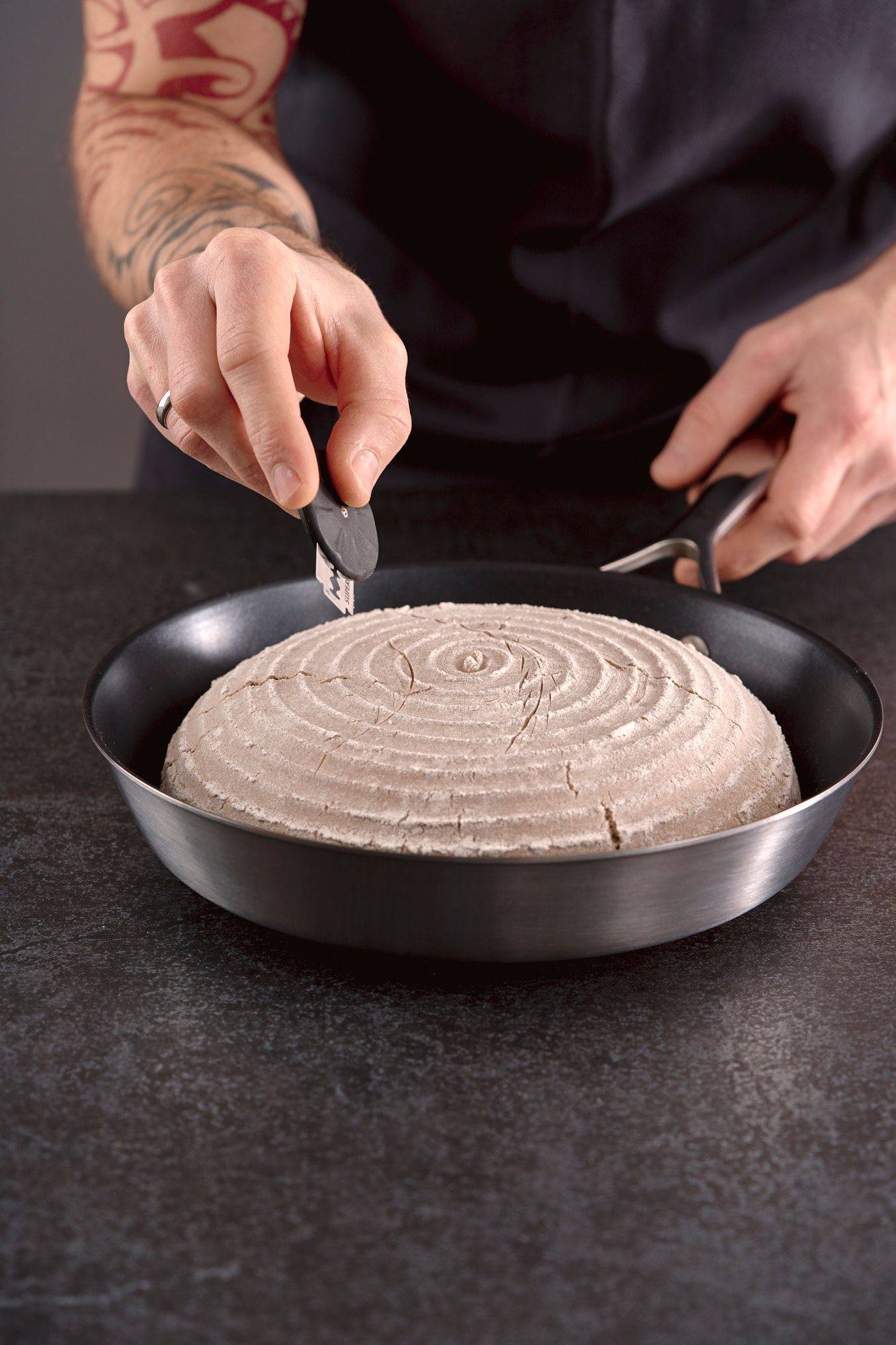 scoring-rye-sourdough-bread man scoring rye sourdough bread in home kitchen