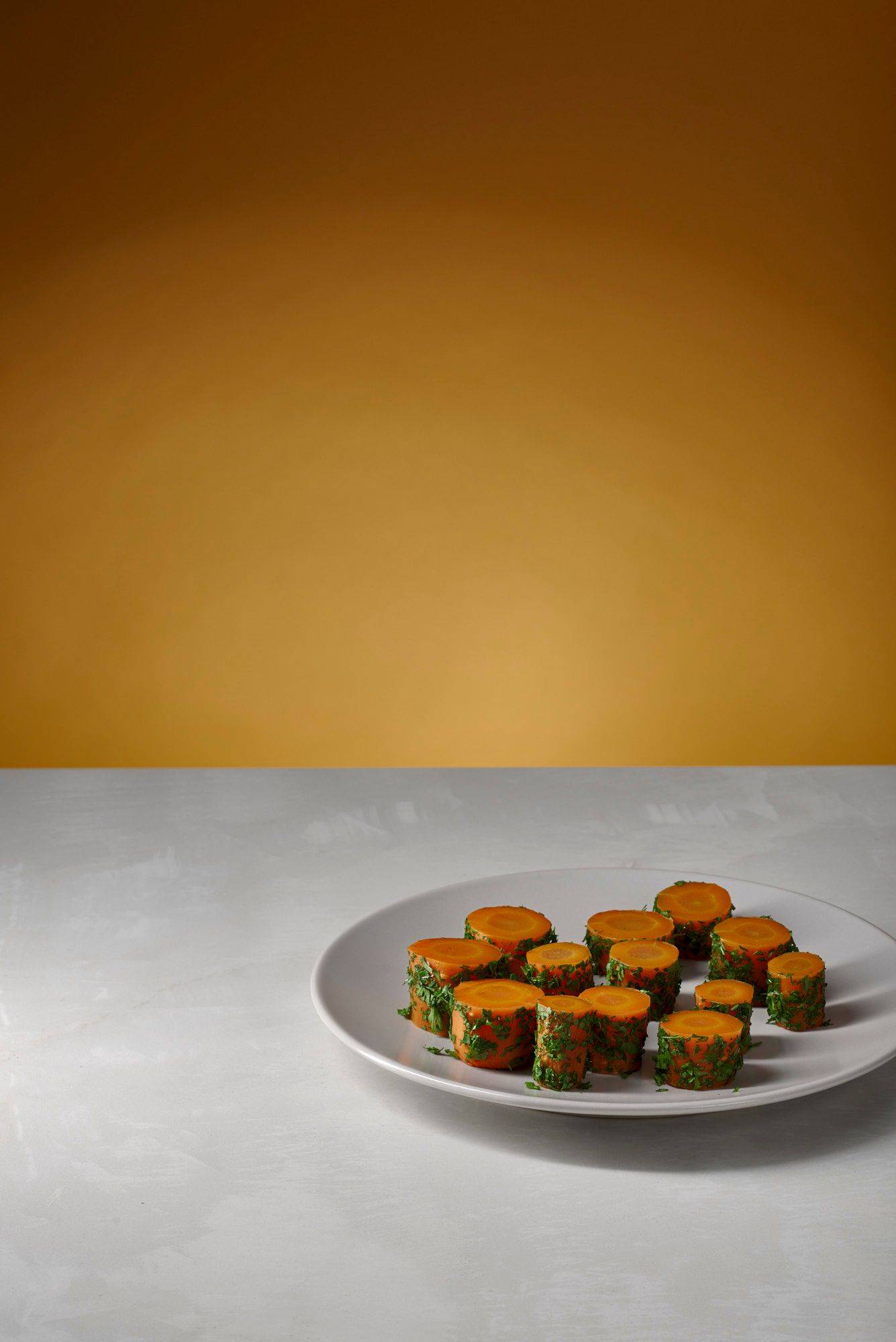 hay-carrots hay carrots on a white plate with white sapienstone top and yellow background