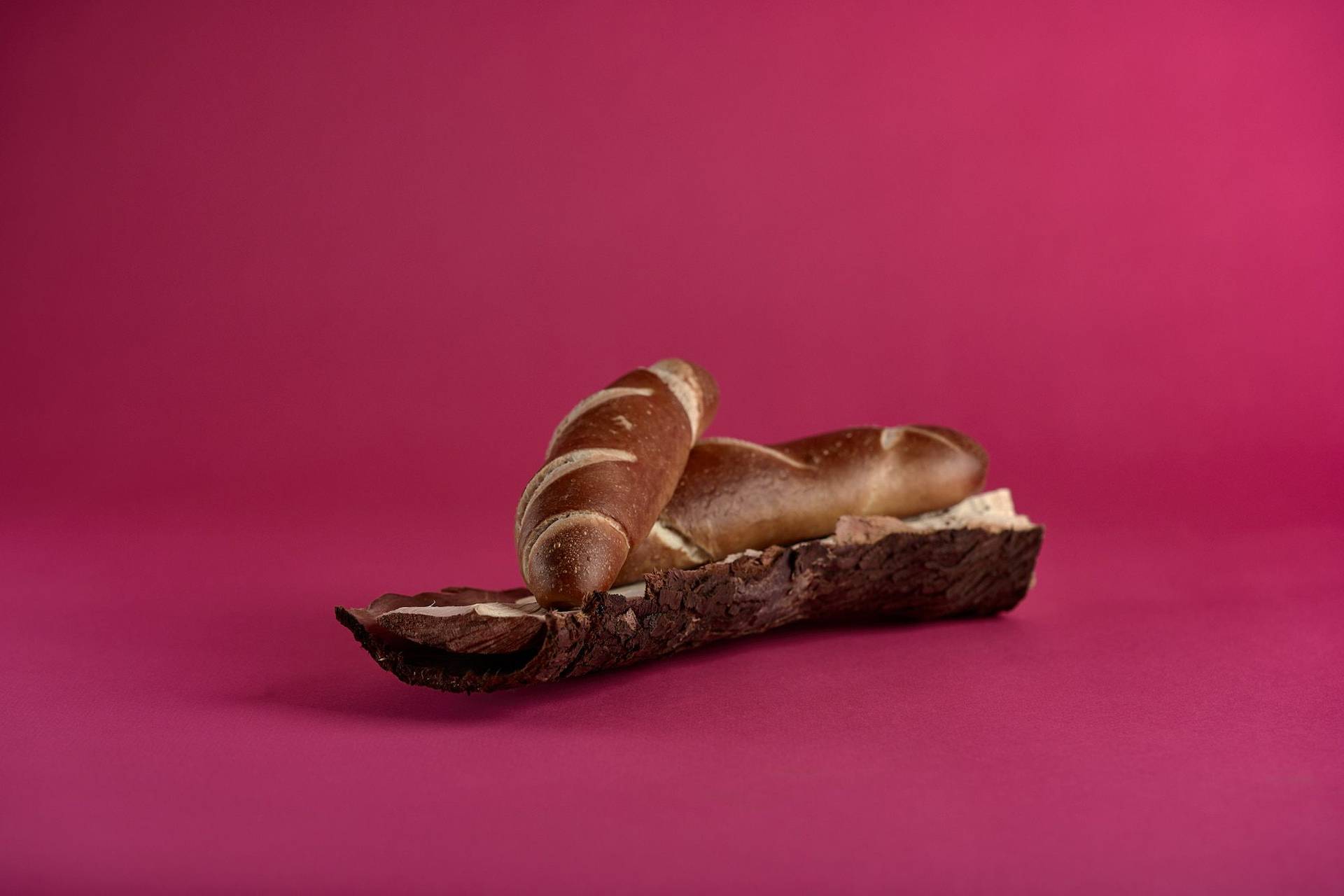 pretzel-sticks pretzel sticks on a piece of wood on pink background