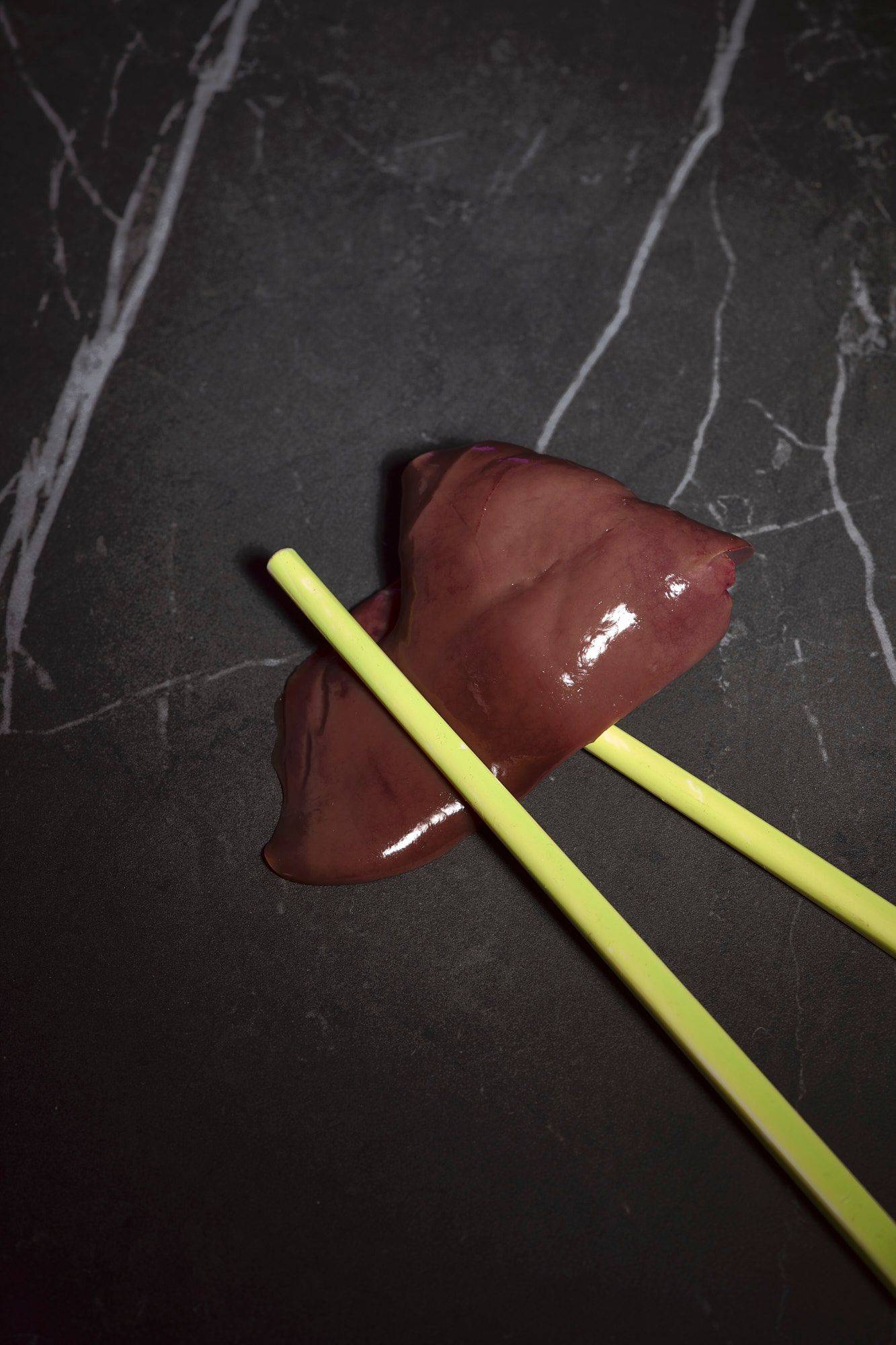 raw-chicken-liver raw chicken liver with yellow chopsticks on a gray marbled sapienstone top