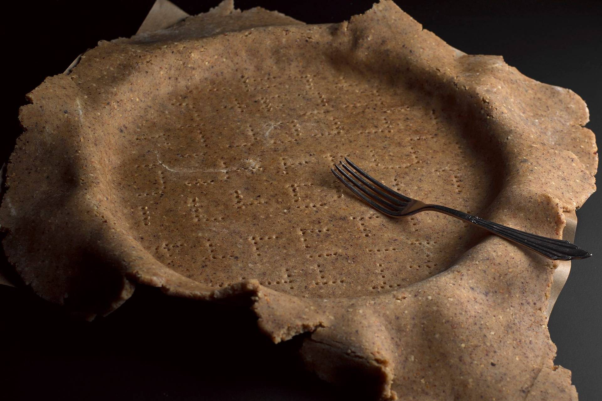 haselnuss-sable haselnuss sablé in einer tarte form mit schwarzem hintergrund