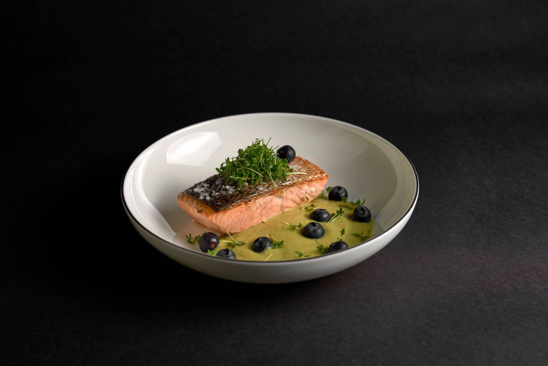 pan-fried-salmon-with-asparagus-matcha-sauce-and-blueberries pan fried salmon with asparagus matcha sauce and blueberries on a white plate with black background