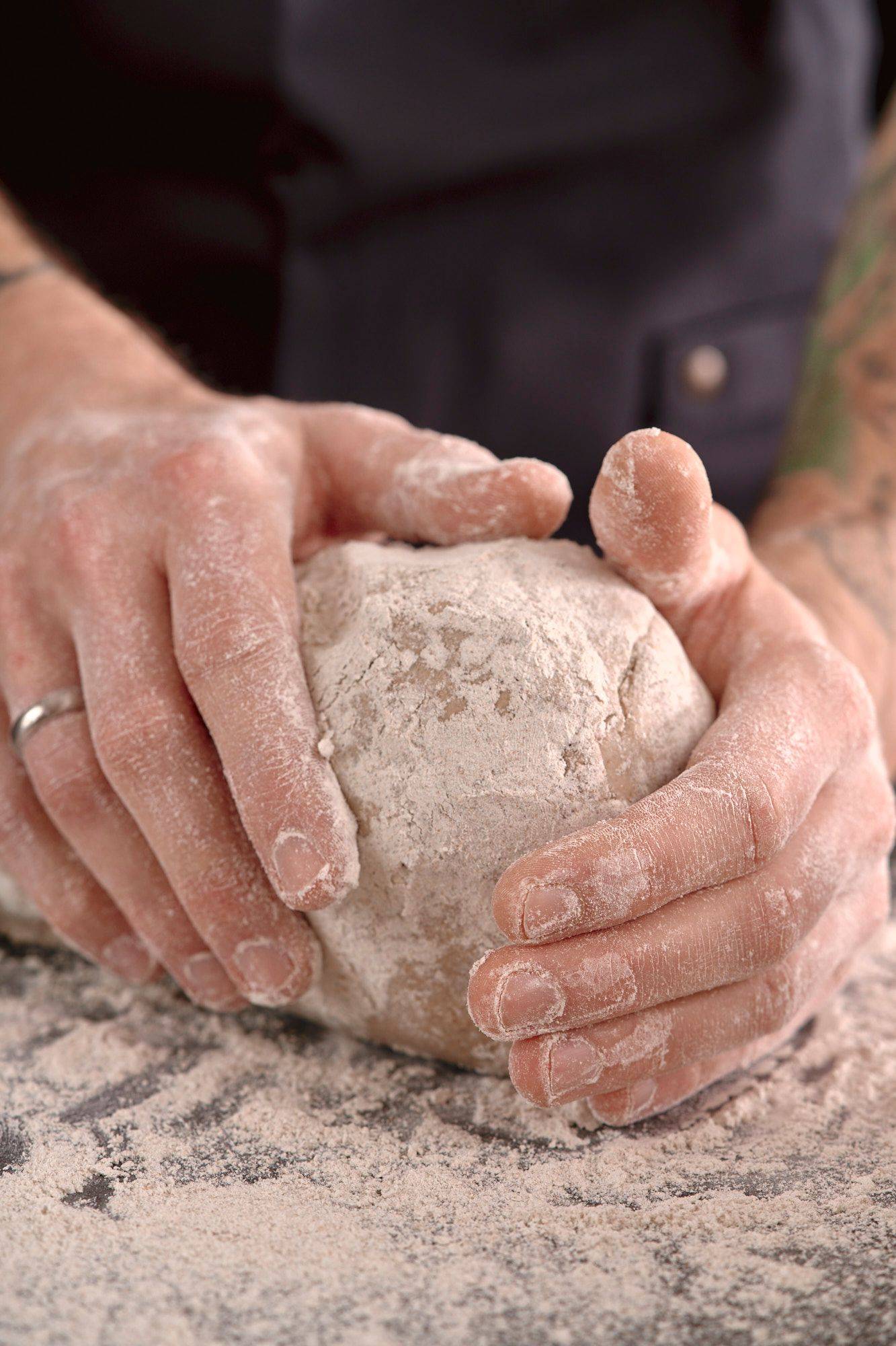 kneading-rye-sourdough man is kneading rye sourdough in home kitchen