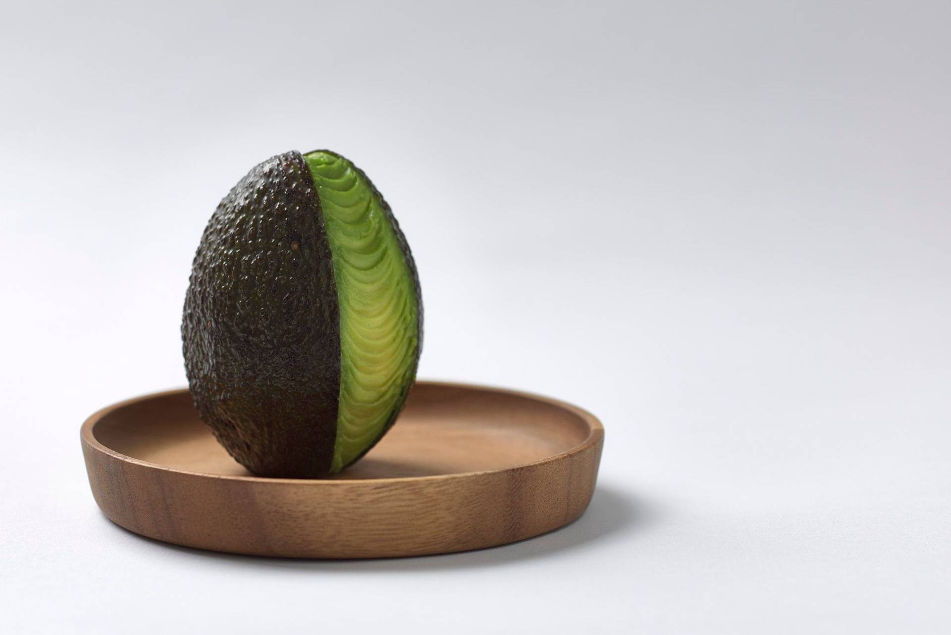 avocado avocado on a wooden plate with white background