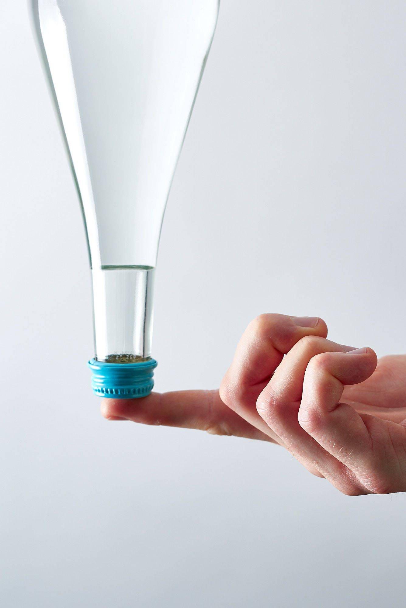 mineral-water mineral water bottle on finger tip with white background