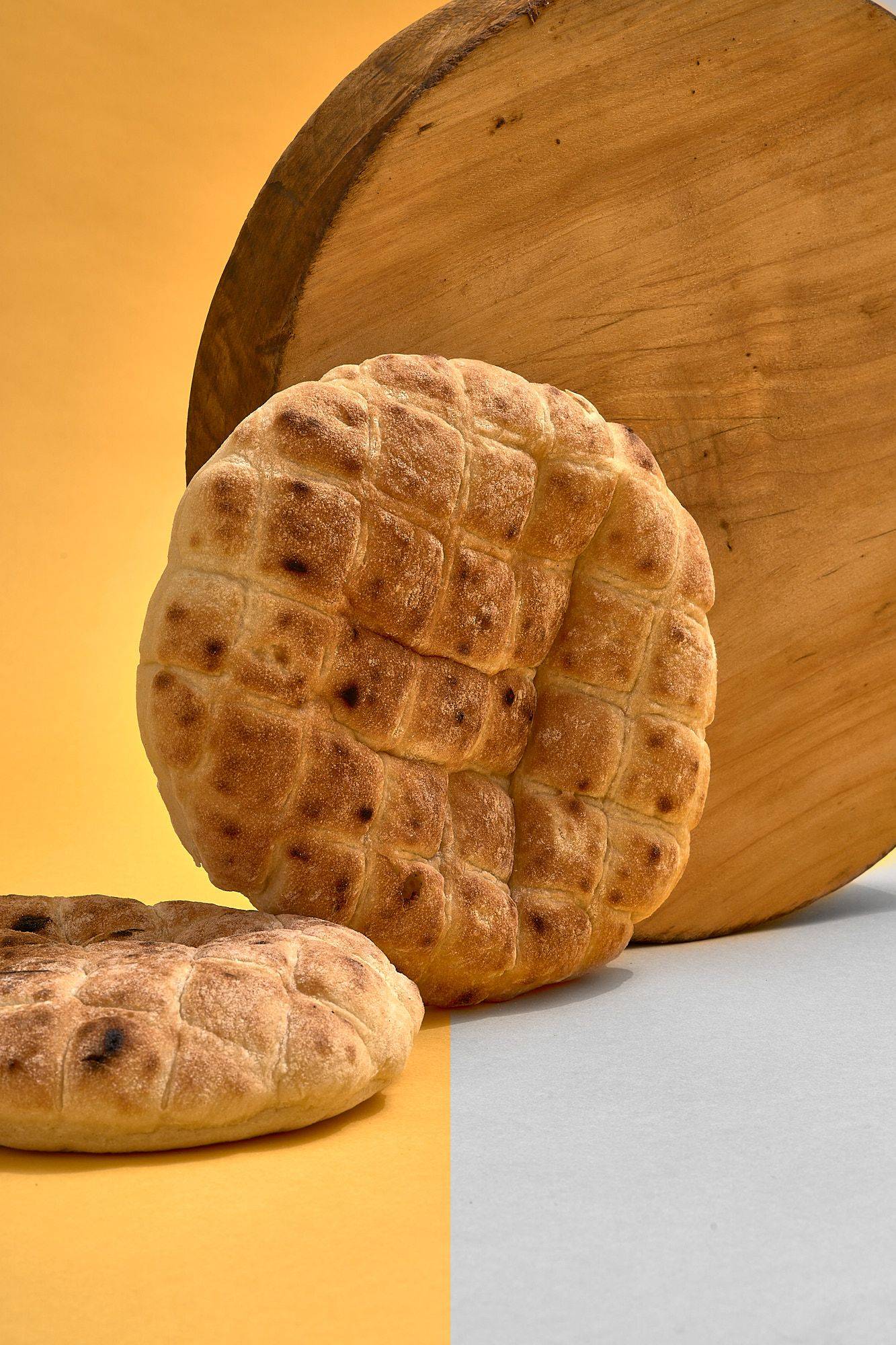 pita-bread pita bread with wooden board on yellow background