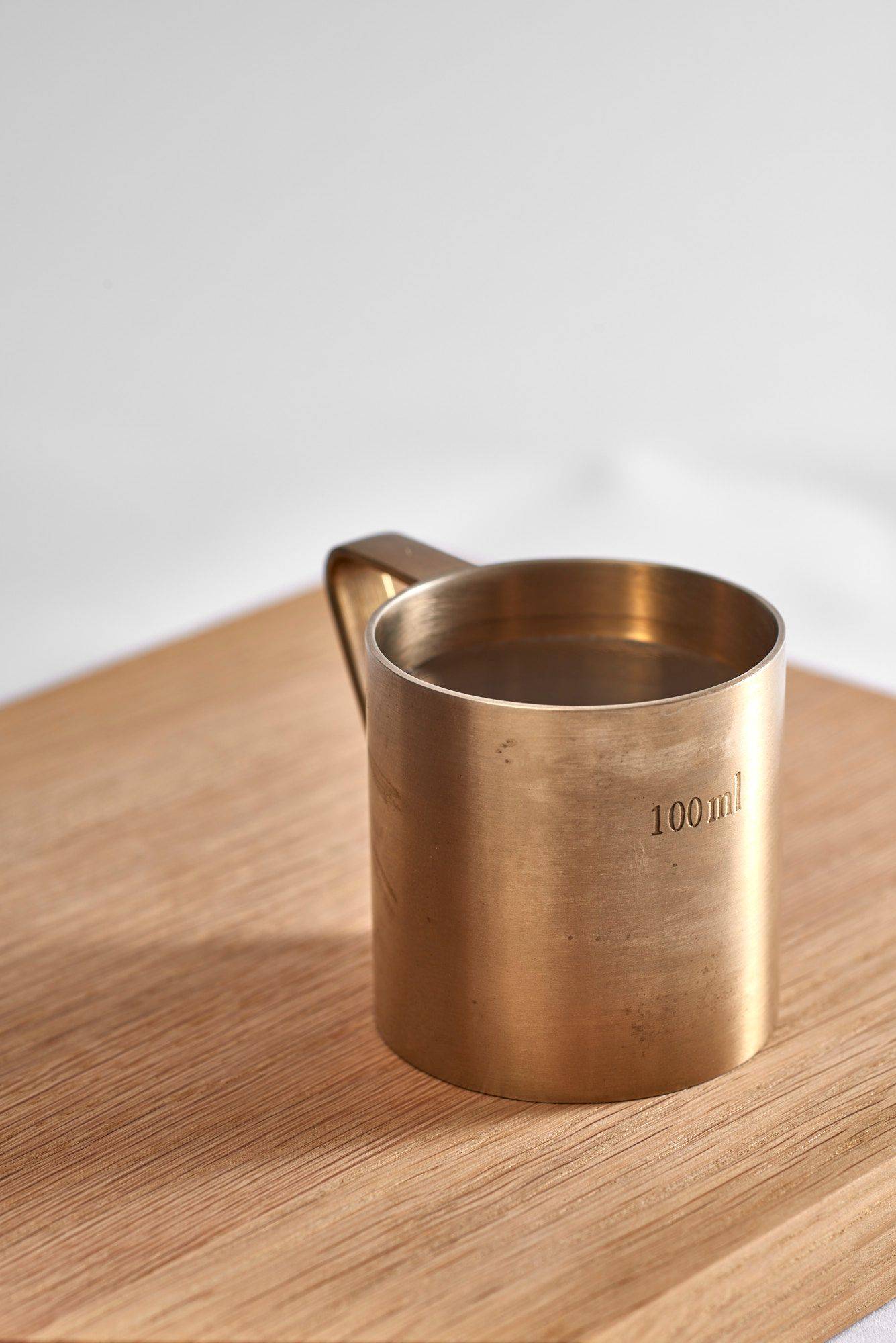 belsazar-vermouth belsazar vermouth in a brass measuring cup on a wooden tray on white background