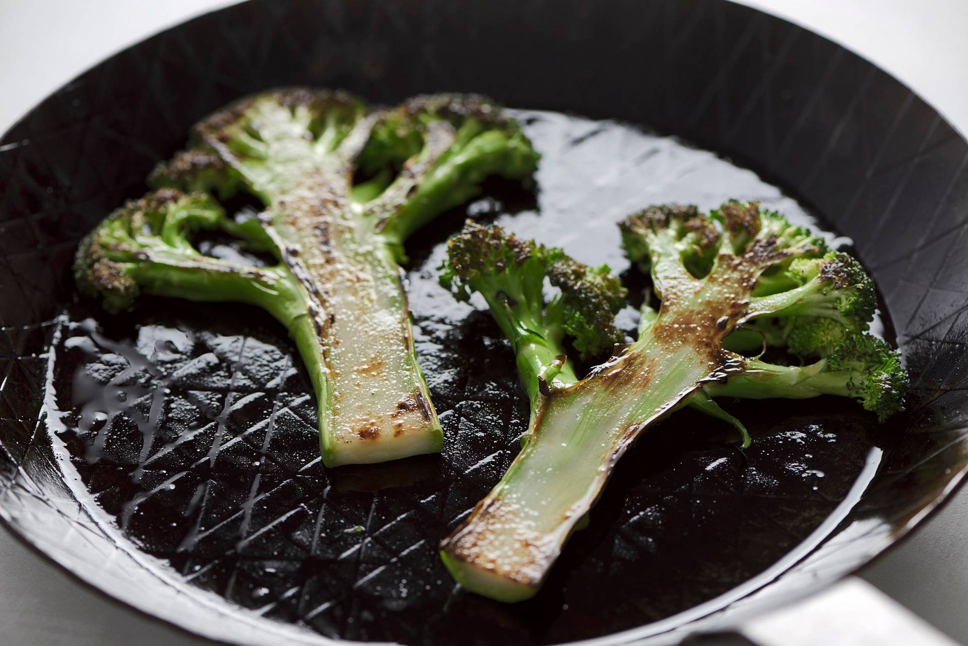 roasted-broccoli roasted broccoli in a cast iron pan on a white sapienstone top