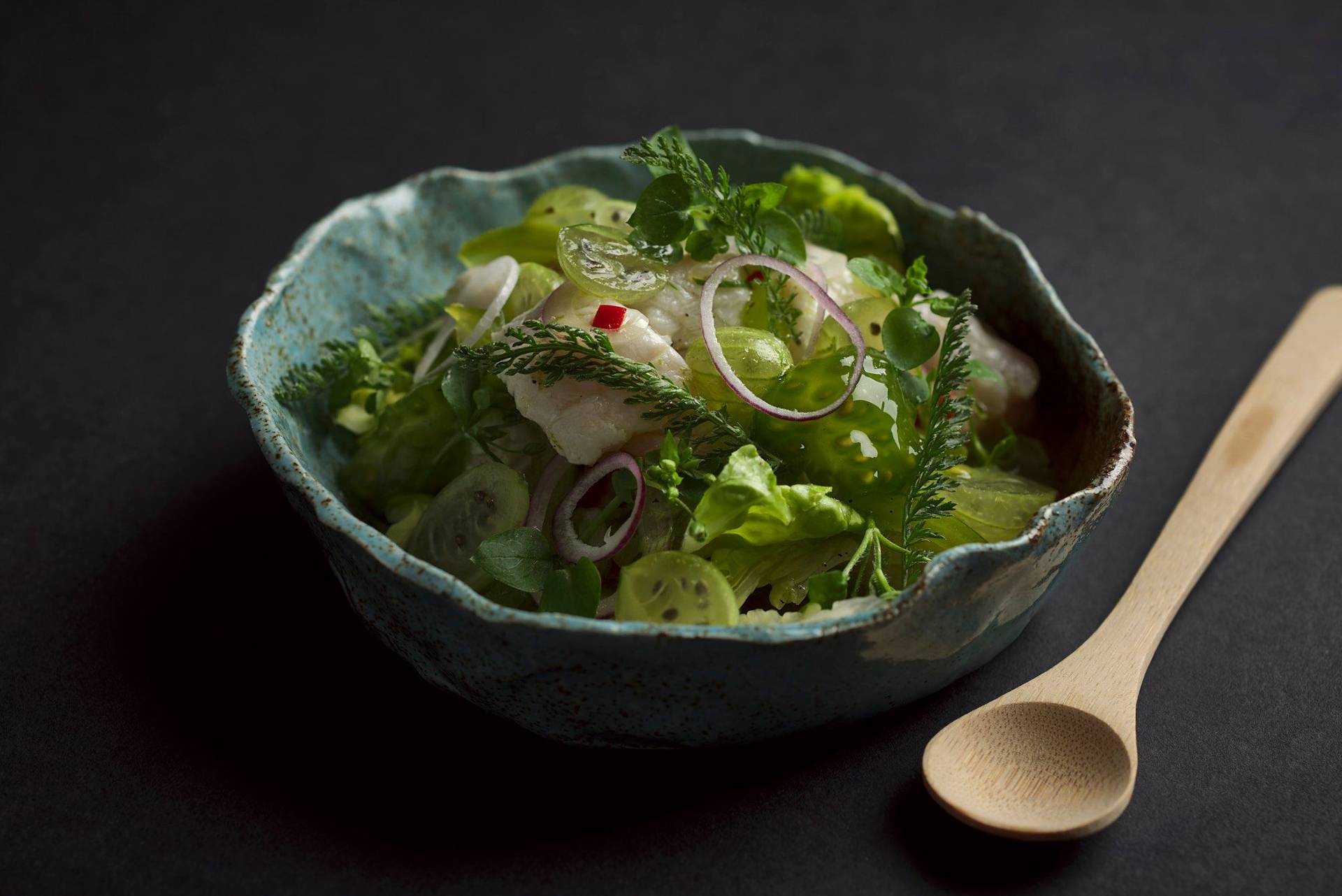 cod-ceviche-with-gooseberries cod ceviche with gooseberries in a turquoise ceramic bowl with black background