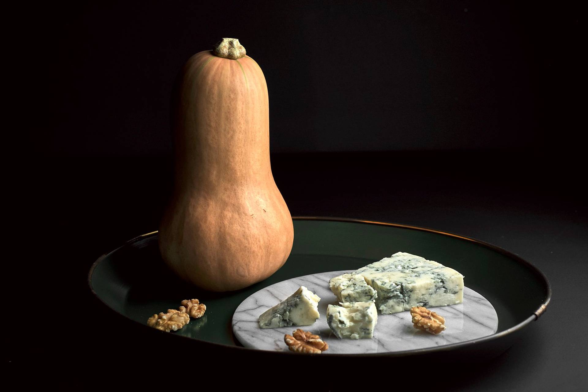 pumpkin-blue-cheese-and-walnuts pumpkin, blue cheese and walnuts on a green plate with black background