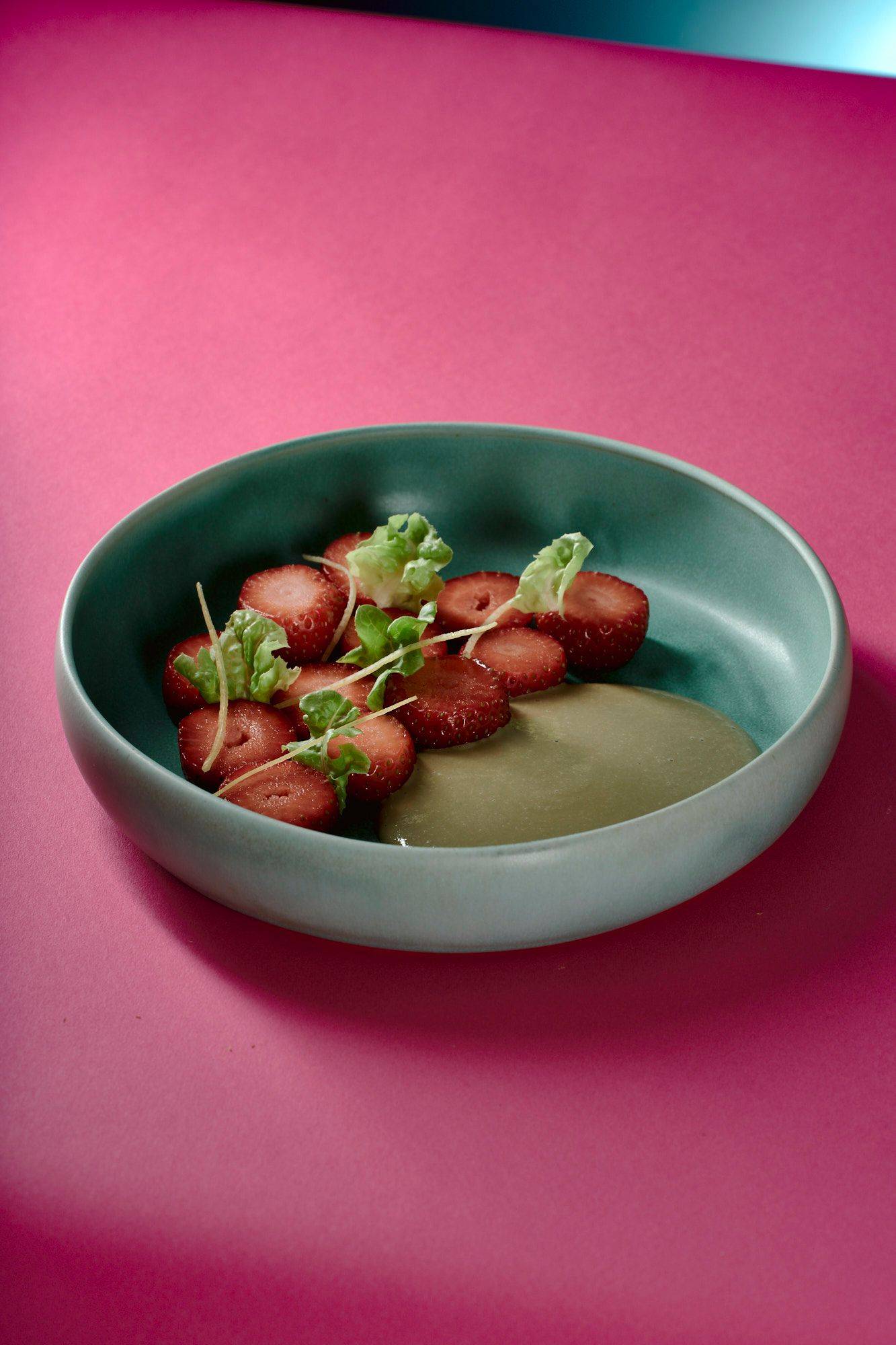vegan-strawberry-dessert-with-lettuce-and-sunflower-seeds vegan strawberry dessert with lettuce and sunflower seeds on a turquoise plate with pink background