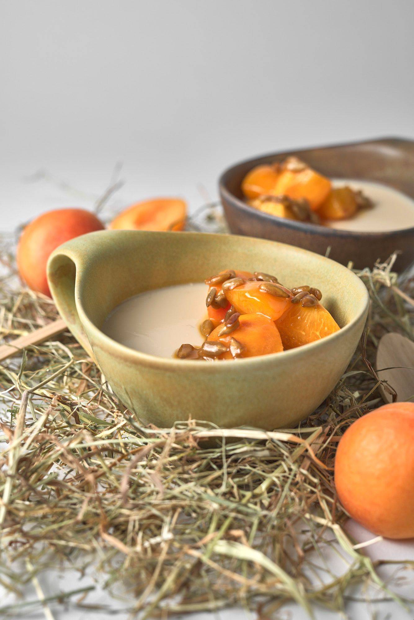 hay-panna-cotta-with-apricots-and-sunflower-seeds hay panna cotta with caramelized apricots and sunflower seeds on white background
