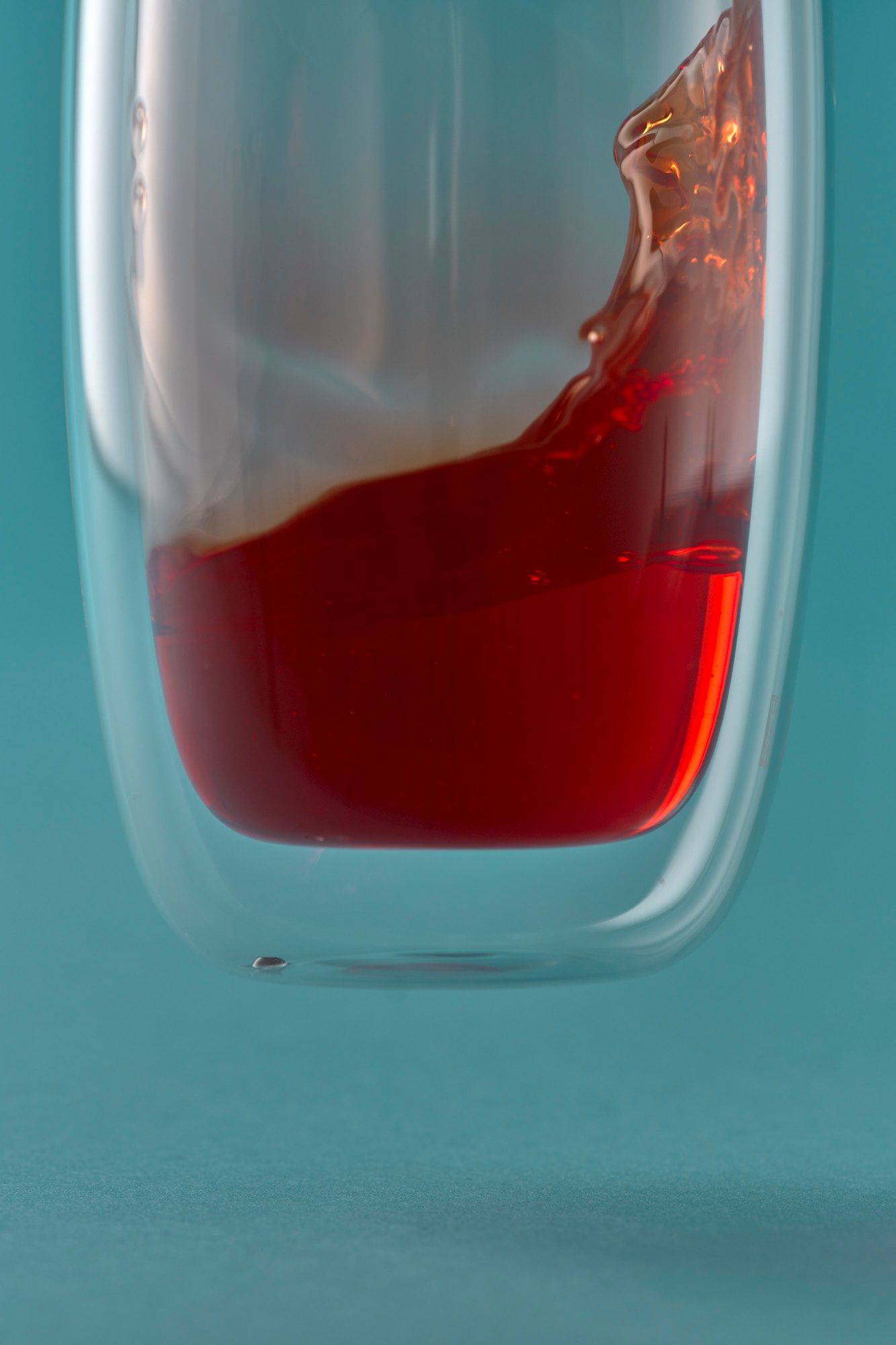 campari-and-aperol a glass with campari and aperol on blue background