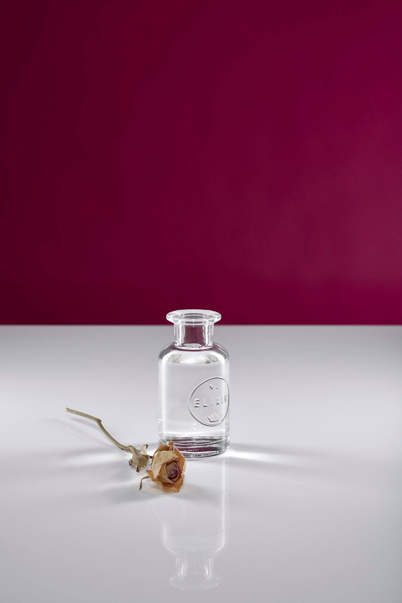 rose-water a glass bottle of rose water with white and pink background