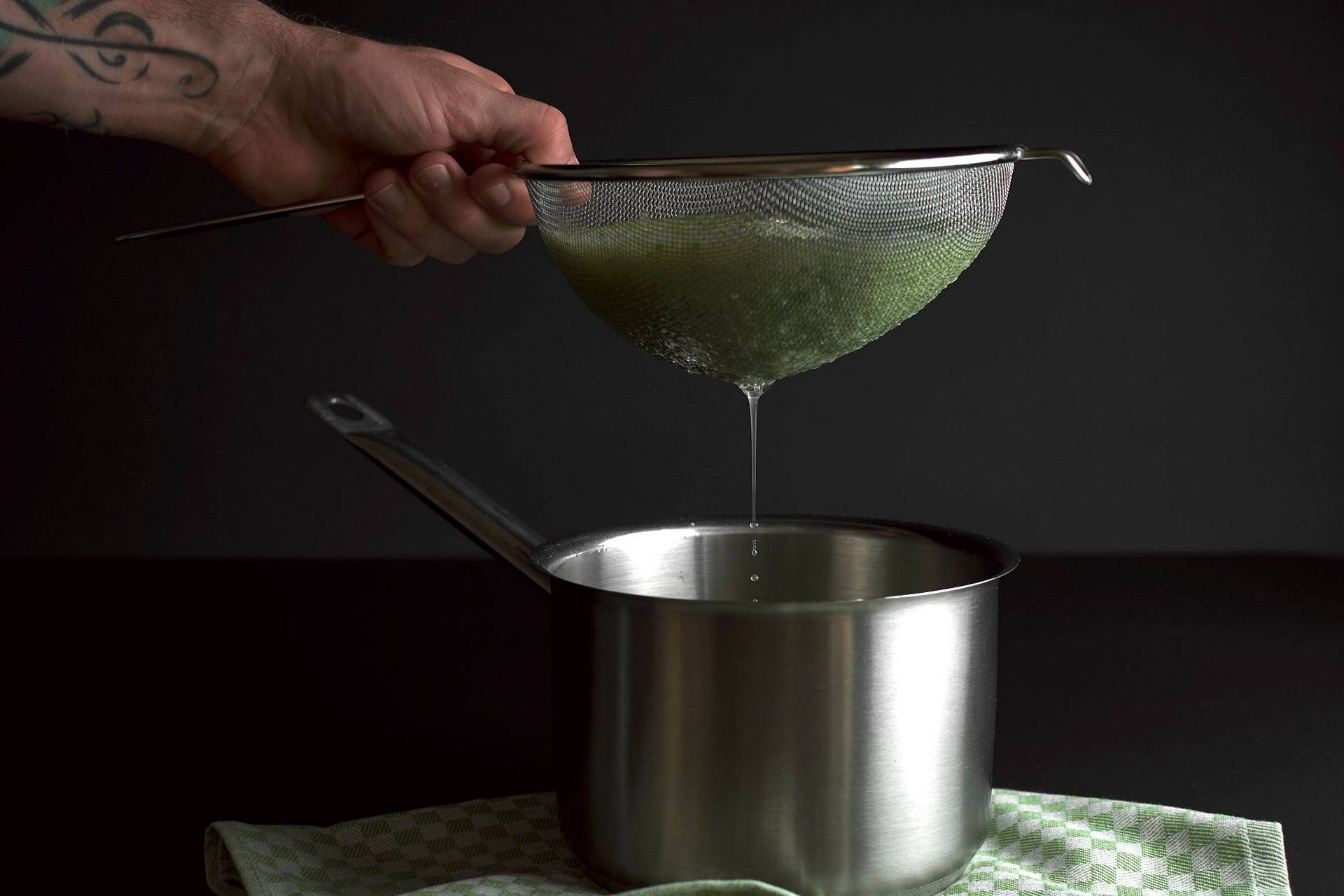 straining-cucumber-lemonade straining cucumber lemonade on black background